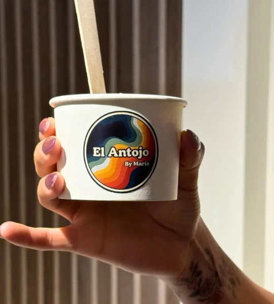 Vaso de antojo con el sello de El Antojo en la mano